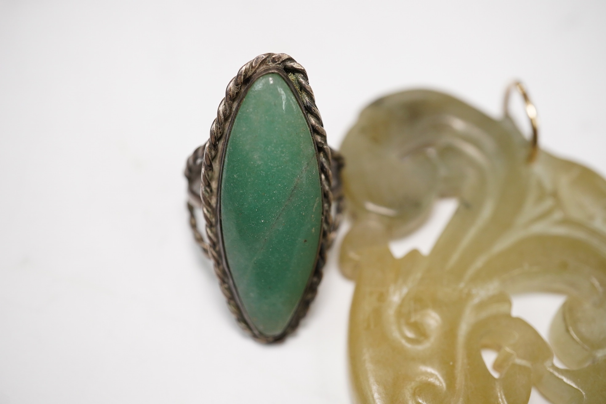 Two jade pendants including a carved example and a jade marquise ring, largest 6.5cm wide. Condition - fair to good